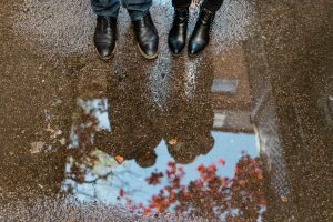 engaged couple rain puddle jumping in boston